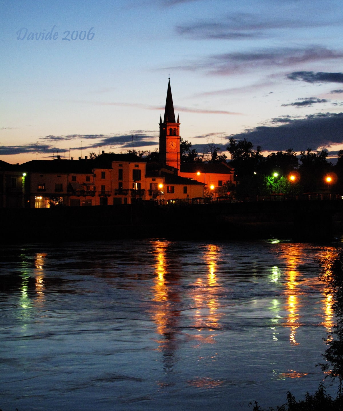 Pizzighettone (Cremona, Lombardia – Italia). Gera, il campanile della chiesa di San Rocco e il fiume Adda al crepuscolo. © Davide. 2006. Fotografia digitale